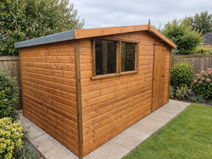 Rosedale 12 x 8 golden shiplap shed installed in a garden